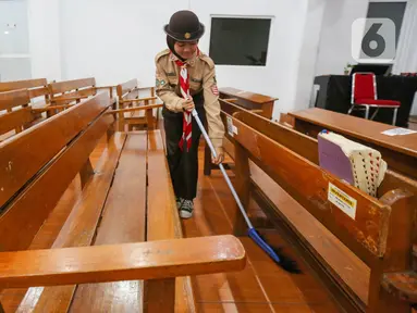 Anggota Praja Muda Karana (Pramuka) membersihkan ruangan ibadah saat kegiatan bakti sosial pramuka di Gereja Kristen Indonesia, Kebon Bawang, Jakarta Utara, Jumat (9/8/2024). (Liputan6.com/Angga Yuniar)