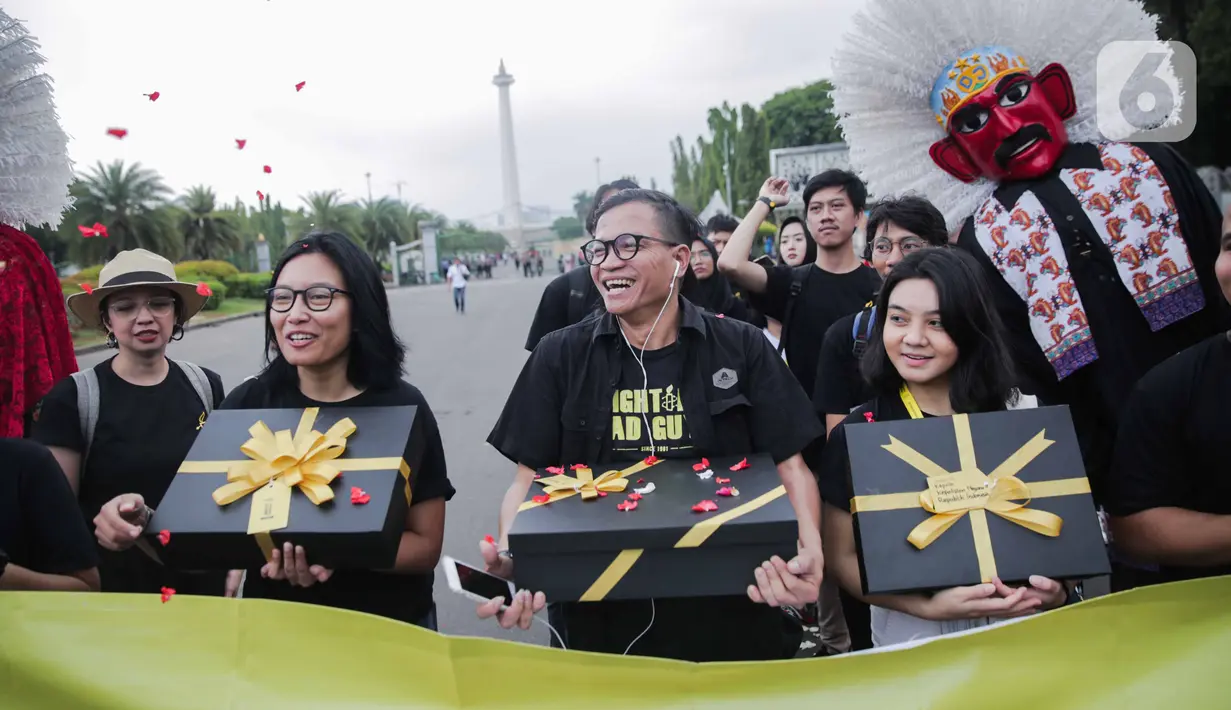 Aktivis yang tergabung dalam Amnesty Internasional Indonesia membawa bingkisan untuk pemerintah saat menggelar aksi di depan Istana Negara, Jakarta, Selasa (10/12/2019). Momen pemberian bingkisan untuk pemerintah dinamakan Aksi Penyerahan Pesan Perubahan (PENA). (Liputan6.com/Faizal Fanani)