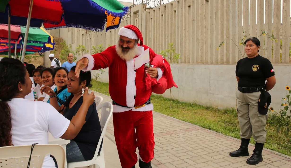 Jose Luis Pereira tahanan asal Extremadura, Spanyol menggenakan kostum santa saat menyapa  narapidana lainnya untuk menyemarakkan perayaan Hari Natal di Penjara Ancon, Callao, Peru, Kamis (22/12). (REUTERS/Mariana Bazo)