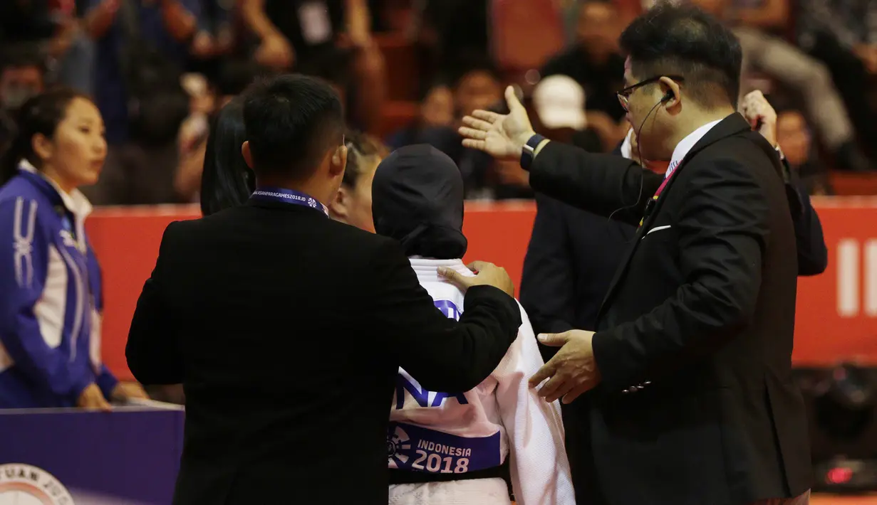 Atlet Judo Indonesia, Miftahul Jannah, meninggalkan lokasi pertandingan usai gagal berlaga pada Asian Para Games di Jiexpo, Kemayoran, Jakarta, Senin (8/10/2018). Miftah didiskualifikasi karena enggan melepas hijab nya. (Bola.com/M Iqbal Ichsan)