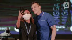 Mantan pemain Arsenal, Mesut Ozil berswafoto saat konferensi pers di kantor Kementerian dan Pariwisata dan Ekonomi Kreatif (Kemenparekraf), Jakarta, Rabu (25/5/2022). Kedatangan perdana Mesut Ozil ke Indonesia ini merupakan bagian dari agenda kolaborasi eks pemain Arsenal tersebut dengan Concave Indonesia. (Liputan6.com/Faizal Fanani)