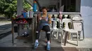 Atlet angkat besi Olimpiade Filipina, Hidilyn Diaz memeriksa pesan pada ponselnya selama sesi Latihan di Jasin di kota Malaka, Malaysia pada 21 Mei 2021. Diaz (30) yang memenangkan perak di Rio 2016 lalu telah tertahan di Malaysia sejak Februari 2020 karena pandemi virus corona. (Mohd RASFAN/AFP)