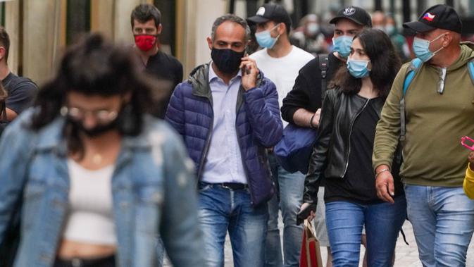 Orang-orang memakai masker untuk mencegah penyebaran COVID-19 saat mereka berjalan-jalan di pusat kota Roma pada Sabtu (3/10/2020). Masker wajah harus dipakai setiap saat di luar rumah di ibu kota Italia, Roma dan wilayah sekitar Lazio mulai Sabtu, 3 Oktober. (AP Photo/Andrew Medichini)