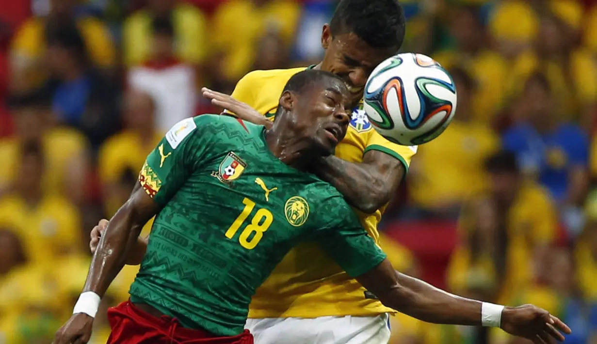 Gelandang Brasil, Luiz Gustavo (belakang) berebut bola dengan pemain tengah Kamerun, Enoh Eyong, saat berlaga di penyisihan Piala Dunia 2014 Grup A di Stadion Nasional Brasil, (24/6/2014). (REUTERS/Michael Dalder)