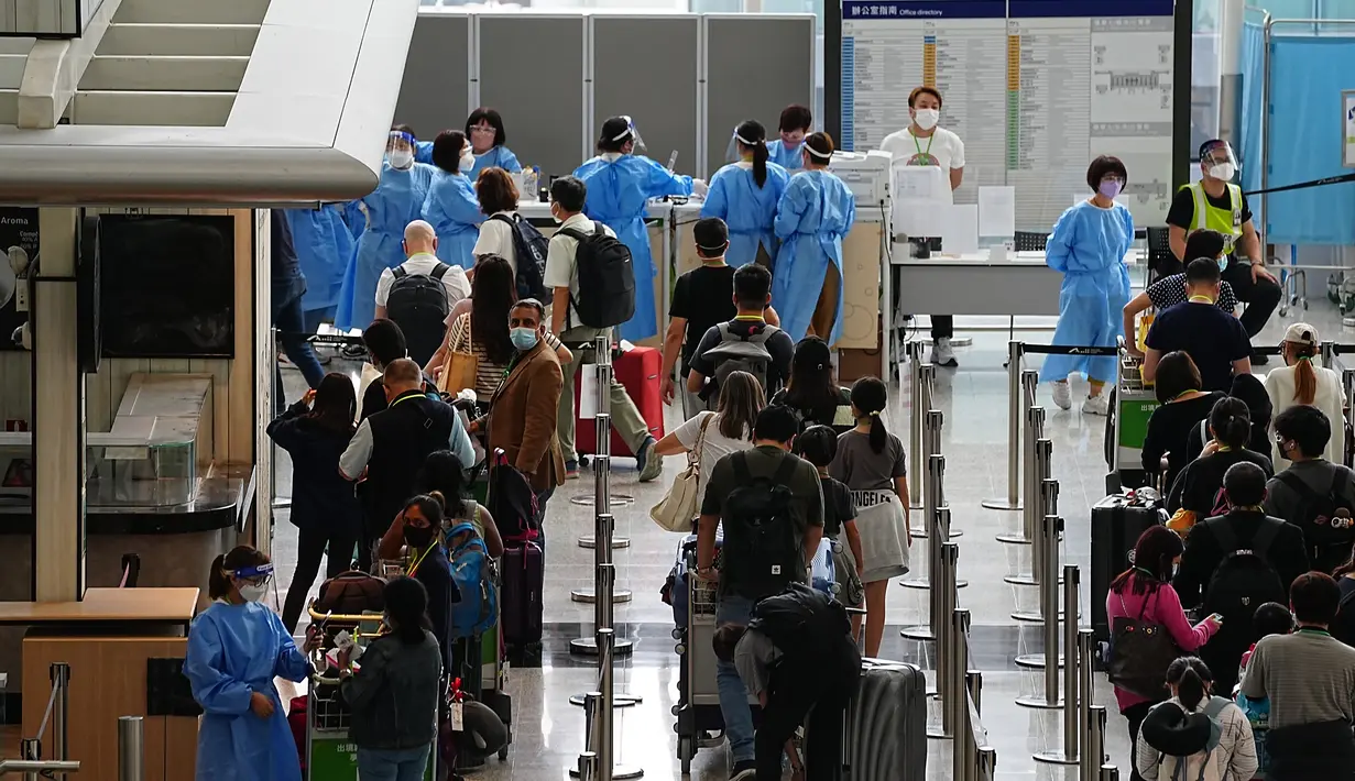 Penumpang mengantre di ruang kedatangan bus menuju hotel karantina COVID-19 dari bandara internasional Hong Kong di Hong Kong, Jumat (23/9/2022). Selama hampir dua tahun, Hong Kong mewajibkan kedatangan luar negeri di kota itu untuk menjalani masa karantina wajib di hotel-hotel yang ditunjuk. (AP Photo/Lam Yik)