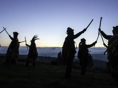 Anggota Powderkeg Morris Dancers menari di atas Windgather Rocks di High Peak di Derbyshire sebelum matahari terbit (1/5). Mereka melakukan tarian tahunan sebagai bagian dari festival Celtic kuno. (AFP Photo/Lindsey Parnaby)