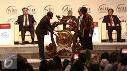 Presiden RI, Jokowi memukul gong sebagai tanda telah  dibuka World Islamic Economic Forum ke-12 di Jakarta, Selasa (2/8). Pertemuan KTT WIEF ke-12 Tahun 2016 berlangsung 2 - 4 Agustus. (Liputan6.com/Faizal Fanani)