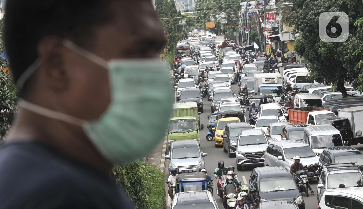 Warga melintasi JPO saat kemacetan terjadi di depan Pasar Pramuka, Jakarta, Senin (16/3/2020). Pasar Pramuka diserbu pembeli yang mencari masker guna mengantisipasi virus Corona, membuat sebagian badan jalan dimanfaatkan sebagai parkiran sehingga menyebabkan kemacetan. (merdeka.com/Iqbal Nugroho)