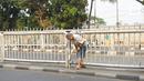 Warga menerobos celah pagar pembatas jalan di depan Stasiun Pasar Minggu, Jakarta, Rabu (16/10/2019). Jauhnya jembatan penyeberangan orang (JPO) membuat warga memanfaatkan celah pagar pembatas tersebut sebagai akses menyeberang, meski berbahaya bagi keselamatan. (Liputan6.com/Immanuel Antonius)