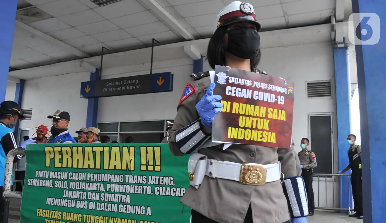 Seorang Polwan Direktorat Lalu Lintas Polda Jawa Tengah menunjukkan poster Cegah Covid-19 saat sterilisasi puluhan angkutan bus yang masuk di Terminal Bawen, Jumat (27/3/2020). (Liputan6.com/Gholib)