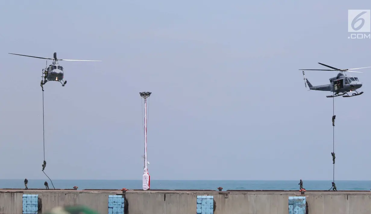Atraksi Prajurit TNI turun dari helikopter pada peringatan HUT ke-72 TNI di Dermaga Indah Kiat Cilegon, Banten, Kamis (5/10). TNI menampilkan sejumlah atraksi memukau para prajurit serta kecanggihan sejumlah alutsista. (Liputan6.com/Angga Yuniar)