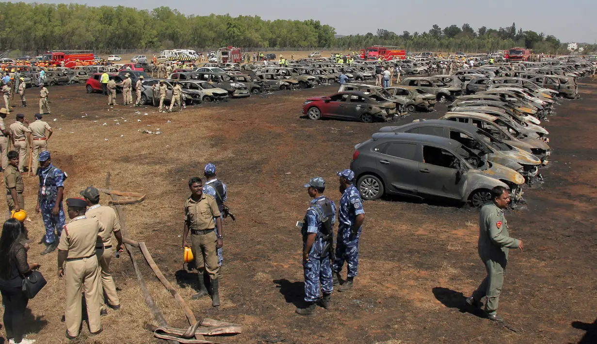Petugas pemadam kebakaran memadamkan api yang membakar deretan mobil di area parkir pameran dirgantara Aero India 2019, Bangalore, India, Sabtu (23/2). Sejauh ini belum ada laporan mengenai korban jiwa. (STR/AFP)