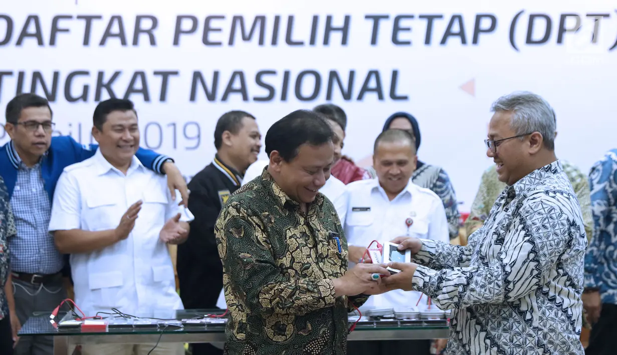 Ketua KPU RI, Arief Budiman (kanan) menyerahkan soft copy DPT tingkat nasional kepada Ketua Bawaslu RI, Abhan usai rapat pleno di Jakarta, Rabu (5/9). Sebelumnya, KPU menggelar rapat pleno rekapitulasi DPT nasional. (Liputan6.com/Helmi Fithriansyah)