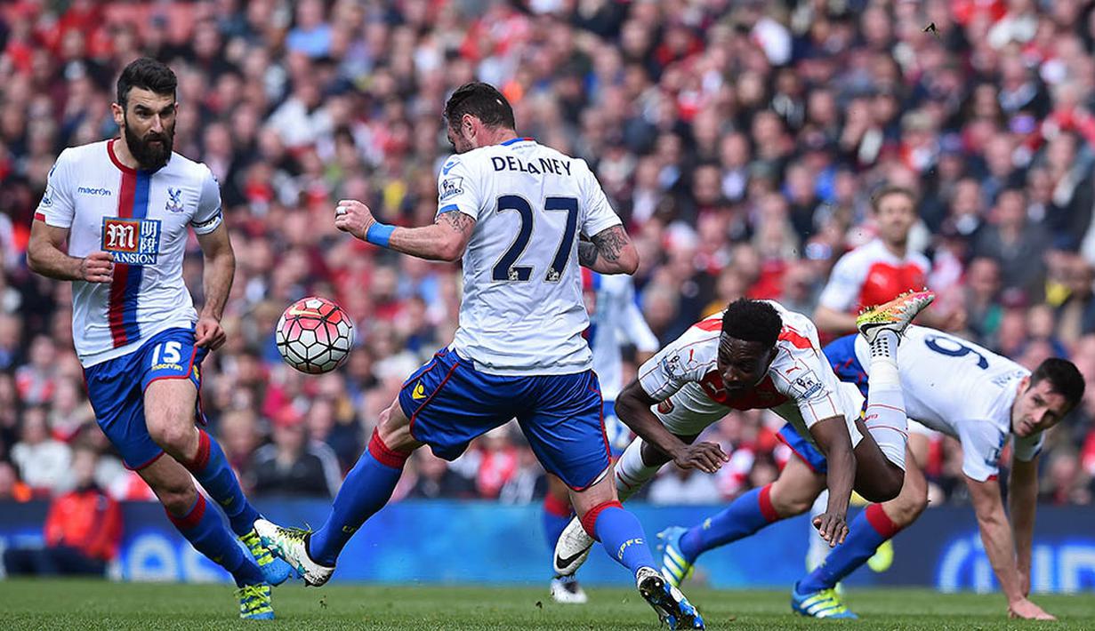Striker Arsenal, Danny Welbeck, terjatuh berebut bola dengan bek Crystal Palace, Scott Dann, pada laga Liga Premier Inggris di Stadion Emirates, London, Minggu (17/4/2016). Sementara itu Palace masih tertahan pada posisi ke-16. (AFP/Ben Stansall)