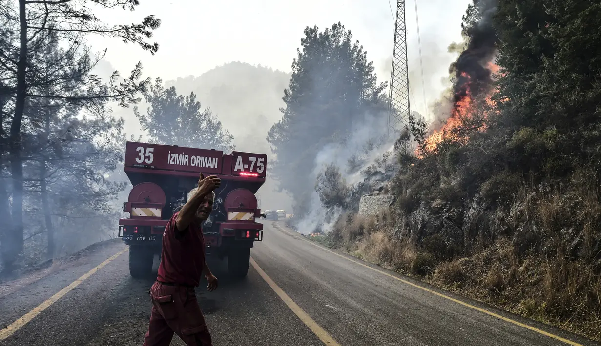 Petugas pemadam kebakaran bekerja saat kebakaran hutan melanda daerah dekat pantai di Bodrum, Mugla, Turki, Minggu (1/8/2021). Kebakaran hutan di tujuan wisata Turki, Antalya dan Mugla, masih berkobar. (Ismail Coskun/IHA via AP)