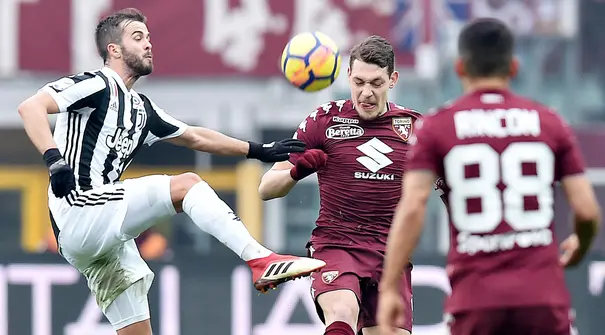Pemain Torino, Andrea Belotti (tengah) berebut bola dengan pemain Juventus, Miralem Pjanic (kiri) pada laga Serie A di Turin Olympic Stadium, Torino, (18/2/2018). Juventus menang 1-0. (Alessandro Di Marco/ANSA via AP)