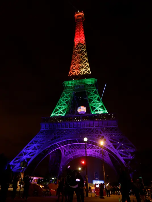 Pemandangan Menara Eiffel di Paris yang menampilkan warna pelangi pada Senin (13/6/2016)  malam, sebagai penghormatan untuk para korban penembakan brutal di klub malam gay di Orlando, Florida AS. (Thomas SAMSON/AFP)