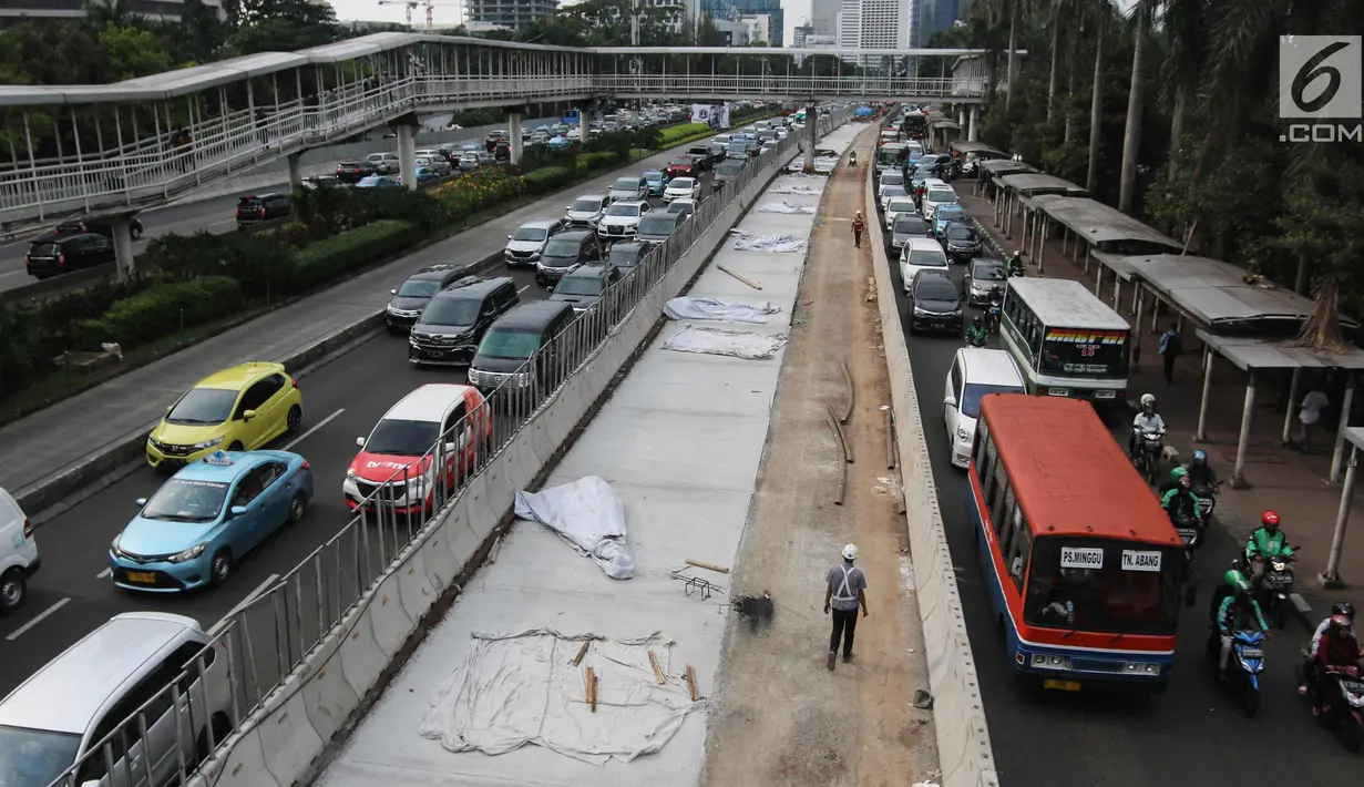 Sejumlah kendaraan terjebak macet di samping penataan jalan dan trotoar di Jalan Sudirman, Jakarta, Selasa (17/4). Trotoar tersebut akan dilebarkan menjadi 9 hingga 12 meter. (Liputan6.com/Arya Manggala)