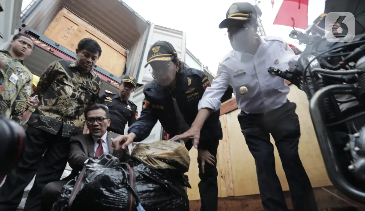 Menkeu Sri Mulyani mengecek barang bukti kasus penyelundupan mobil dan motor mewah di Terminal Petikemas Koja, Jakarta, Selasa (17/12/2019). Potensi kerugian negara akibat penyelundupan mobil dan motor mewah tersebut mencapai Rp 48 miliar. (merdeka.com/Iqbal Nugroho)
