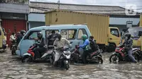 Arus lalu lintas tersendat saat melintasi banjir rob di Jalan Lodan Raya, Ancol, Jakarta, Senin (6/12/2021). Banjir akibat pasang air laut kembali merendam permukiman warga dan menggenangi Jalan Lodan Raya hingga ketinggian 50 cm yang menyebabkan kemacetan lalu lintas. (merdeka.com/Iqbal S Nugroho)