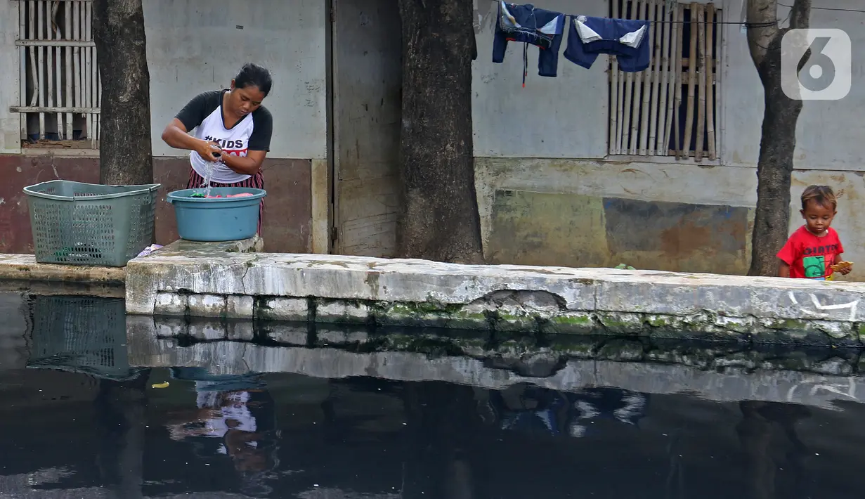 Warga mencuci pakaian di Kali Cilemahabang yang menghitam di kawasan Karangbahagia, Kabupaten Bekasi, Jawa Barat, Selasa (7/9/2021). Warga berharap Pemerintah Kabupaten Bekasi menindaklanjuti sebab menghitamnya Kali Cilemahabang. (Liputan6.com/ Herman Zakharia)