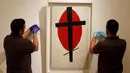 Petugas saat menyiapkan lukisan " Mystic Suprematisme " karya Kasimir Malevich di London, Inggris, Jumat (9/10/2015). Lukisan ini diperkirakan terjual hingga ratusan miliar pada pelelangan di New York 5 November nanti. (REUTERS/Stefan Wermuth)   