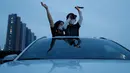 Seorang anggota keluarga melambaikan tangan ketika menonton konser drive-in Stage X di sebuah tempat parkir di Goyang, 23 Mei 2020. Konser ini untuk memberikan hiburan bagi warga Korea Selatan yang mendambakan acara-acara musik yang ditangguhkan selama pandemi Covid-19. (AP Photo/Ahn Young-joo)