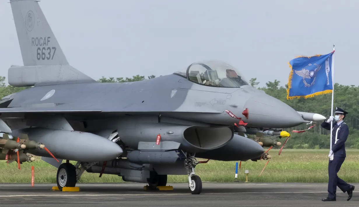 Pembawa bendera Angkatan Udara Taiwan melewati salah satu jet tempur F-16V yang baru di pangkalan Angkatan Udara di Chiayi di barat daya Taiwan, Kamis (18/11/2021). Langkah Taiwan tersebut untuk meningkatkan kemampuan pertahanannya dalam menghadapi ancaman berkelanjutan dari China. (AP Photo/Johnson