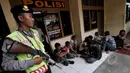 Petugas polisi berjaga mengamankan sejumlah preman di kawasan terminal Pulogadung, Jakarta, Kamis, (12/3/2015). Petugas berhasil menyita minuman keras, senjata tajam, dan belasan orang yang diduga preman di lokasi tersebut. (Liputan6.com/Johan Tallo)