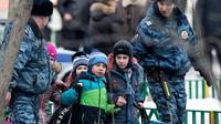 Petugas polisi mengamankan siswa atas penembakan sekolah yang terjadi di Moskow pada tahun 2014. (AFP)