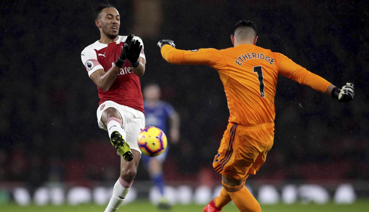 Striker Arsenal, Pierre-Emerick Aubameyang, berebut bola dengan kiper Cardiff City, Neil Etheridge, pada laga Premier League di Stadion Emirates, Rabu (30/1). Arsenal menang 2-1 atas Cardiff City. (AP/Nick Potts)