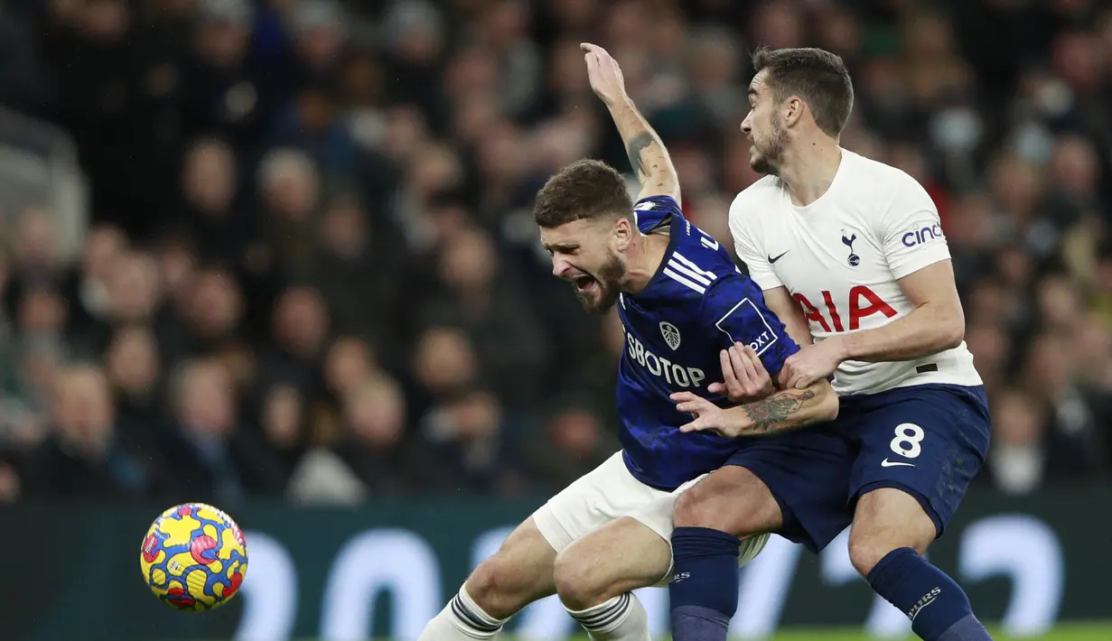 Gelandang Tottenham Hotspur, Harry Winks berebut bola dengan bek Leeds United Liam Cooper pada pekan ke-12 Liga Inggris di Tottenham Hotspur Stadium, London, Minggu (21/11/2021). Sempat tertinggal, Tottenham Hotspur menumbangkan Leeds United 2-1. (AP Photo/Ian Walton)