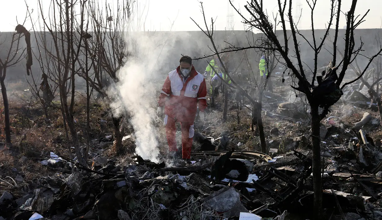 Tim penyelamat mencari korban pesawat Boeing 737 milik maskapai Ukraina yang jatuh di Shahedshahr, Iran, Rabu (8/1/2020). Pesawat Ukraine International Airlines tersebut dilaporkan mengangkut 176 orang termasuk kru. (AP Photo/Ebrahim Noroozi)