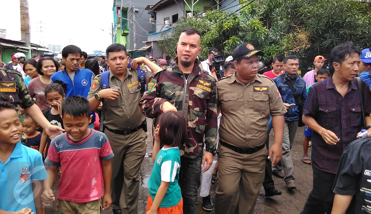 Sejumlah anak berebut mencium tangan dan bersalaman dengan musisi Ahmad Dhani saat tiba di  lokalisasi Kalijodo, Penjaringan, Jakarta, Senin (15/2). Suami dari Mulan Jameela itu mendatangi Kalijodo dikawal Banser Nahdlatul Ulama (NU). (Foto : Muslim AR)