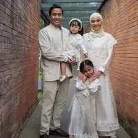 Outer tersebut memiliki detail bunga putih cukup besar di bagian leher yang membuat pakaian terkesan simpel namun tetap mewah. Pakaian tersebut dipadukan heels. Credit: (@inforiamiranda)