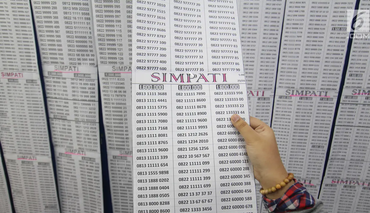Calon pembeli melihat nomor selular prabayar baru di Jakarta, Jumat (3/11). Proses registrasi dengan validasi Nomor Induk Kependudukan atau NIK dan Kartu Keluarga atau KK, sebelum batas akhir Februari 2018. (Liputan6.com/Angga Yuniar)