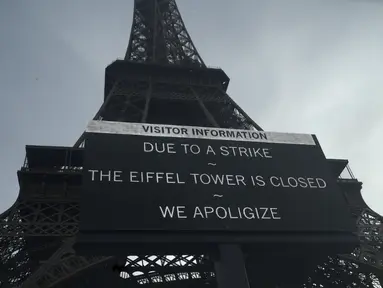 Sebuah papan memperingatkan tentang pemogokan di Menara Eiffel, Paris, Rabu (27/12/2023). (AP Photo/Lewis Joly)