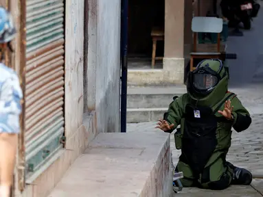 Anggota kepolisian mengenakan pakaian khusus saat menjinakkan bom yang ditemukan di sekitar sekolah di Kathmandu, Nepal, Selasa (20/9). Otoritas berwenang setempat mengabarkan ada 5 sekolah yang ditemukan bom di kota tersebut. (REUTERS/Navesh Chitrakar)