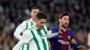 Pemain Barcelona, Lionel Messi  berebut bola dengan pemain Real Betis, Javi Garcia pada pertandingan lanjutan La Liga di Stadion Benito Villamarin, Minggu (21/1). Dua gol Messi membawa Barcelona menang telak 5-0 atas Real Betis. (AP/Miguel Morenatti)