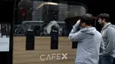Pelanggan menyaksikan robot barista membuat kopi di Cafe X, San Francisco, California, AS, Selasa (12/2). Tetap dibutuhkan satu atau dua pekerja yang mendampingi robot untuk mengantisipasi terjadinya masalah teknis. (Justin Sullivan/Getty Images/AFP)