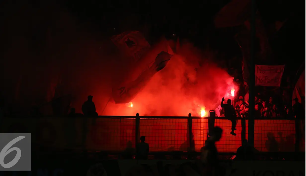 Suasana SUGBK yang merah menyala oleh letupan suar atau red flare saat AS Roma bertanding di Senayan, Jakarta, Sabtu (27/7/2015). AS Roma merasa tersanjung dengan sambutan yang luar biasa oleh fans Indonesia. (Liputan6.com/Herman Zakharia) 