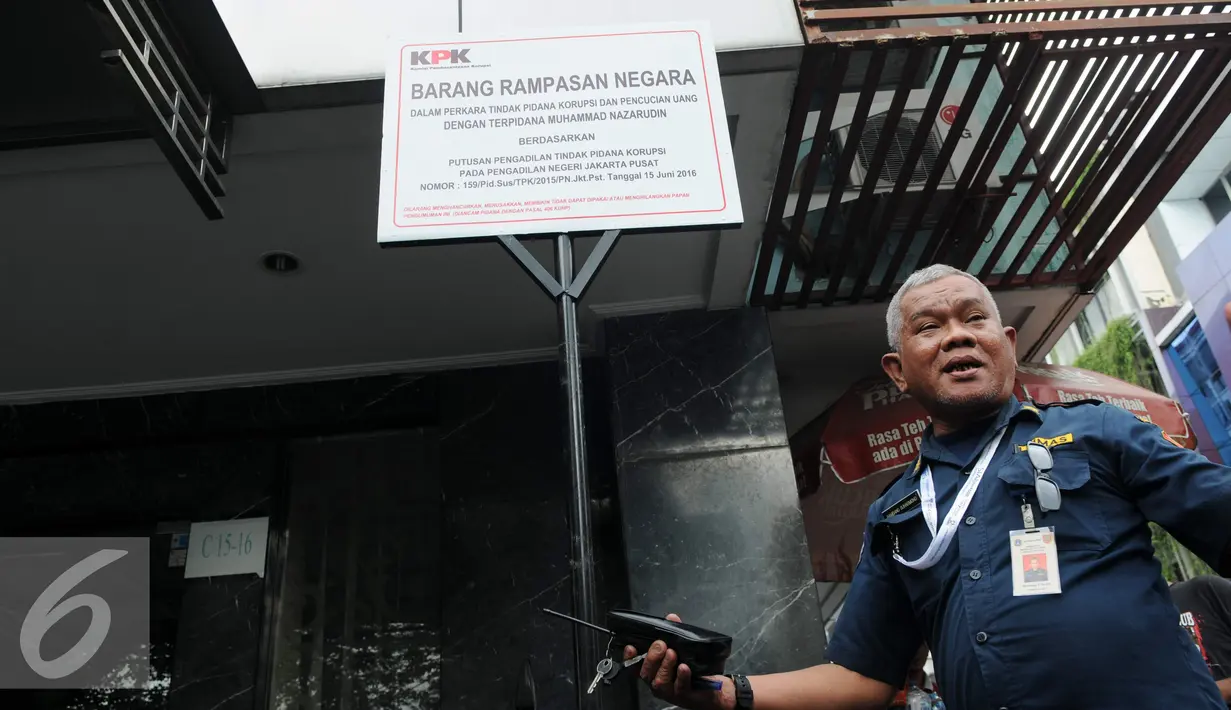 Seorang petugas berdiri di depan plang segel sebuah rumah toko (ruko) yang berada di Wijaya Grand Center, Jakarta Selatan, Senin (28/11). Ruko tersebut masuk dalam daftar kekayaan Nazaruddin yang dirampas negara. (Liputan6.com/Helmi Affandi)