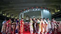 Sejumlah wanita mengenakan busana kimono berpose setelah pembukaan pasar saham untuk tahun ini di Bursa Saham Tokyo, Jepang (4/1). Saham Tokyo melonjak pada hari pertama pembukaan pasar saham. (AP Photo/Kazuhiro Nogi)