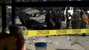 Anggota keamanan Afghanistan memeriksa sebuah mobil yang rusak akibat ledakan bom di jalanan Ibu Kota Afghanistan, Kabul, Rabu (28/12). Kendaraan yang ditumpangi anggota parlemen bernama Fakori Behishti hancur akibat ledakan ini. (WAKIL KOHSAR/AFP)