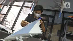 Pekerja menyelesaikan pembuatan miniatur pesawat di workshop Anglo Indonesian Aircraft Models di Cibinong, Kabupaten Bogor, Kamis (15/10/2020). Produk miniatur pesawat buatan Anglo Indonesian Aircraft Models ini telah diekspor ke beberapa negara. (Liputan6.com/Herman Zakharia)