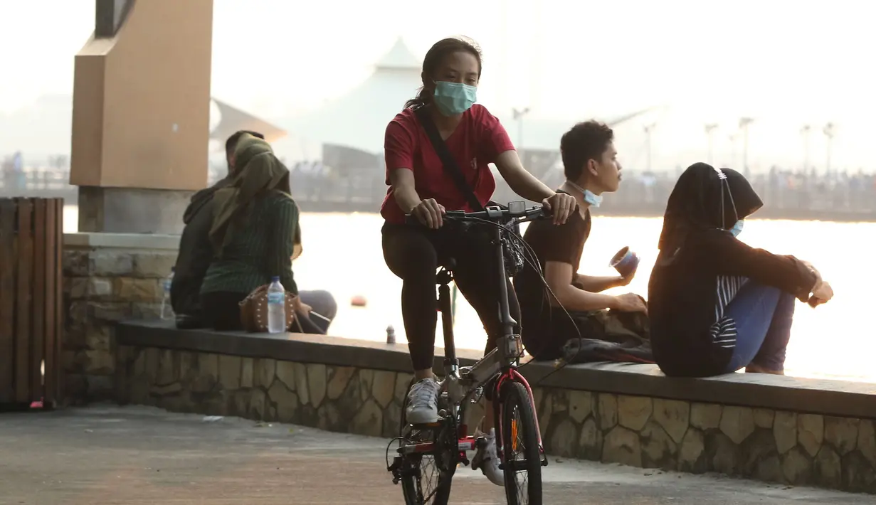 Pengunjung menikmati suasana Pantai Ancol, Jakarta, menjelang berlakunya PSBB, Sabtu (12/9/2020). Pemprov DKI berencana menutup sejumlah tempat rekreasi di antaranya Ancol, Ragunan, Monas, dan Taman Mini Indonesia Indah saat PSBB total pada 14 September mendatang. (Liputan6.com/Herman Zaharia)