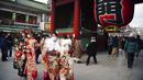 Para wanita berbaju kimono yang baru menginjak usia 20 tahun berfoto dekat Kuil Sensoji di Distrik Asakusa, Tokyo, Jepang, Senin (10/1/2022). Coming of Age Day diadakan setiap tahun pada Senin kedua bulan Januari untuk merayakan remaja Jepang menjadi dewasa. (AP Photo/Eugene Hoshiko)