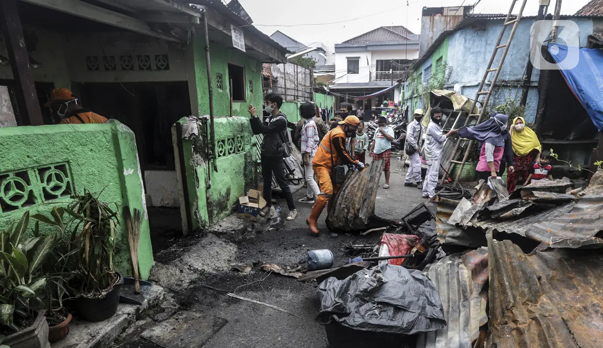Warga dan petugas membersihkan sisa kebakaran di permukiman padat Kelurahan Bali Mester, Jatinegara, Jakarta, Selasa (8/9/2020). Kebakaran di permukiman padat itu melalap 11 rumah tinggal warga serta satu unit bengkel dan mengakibatkan 60 orang mengungsi. (Liputan6.com/Johan Tallo)