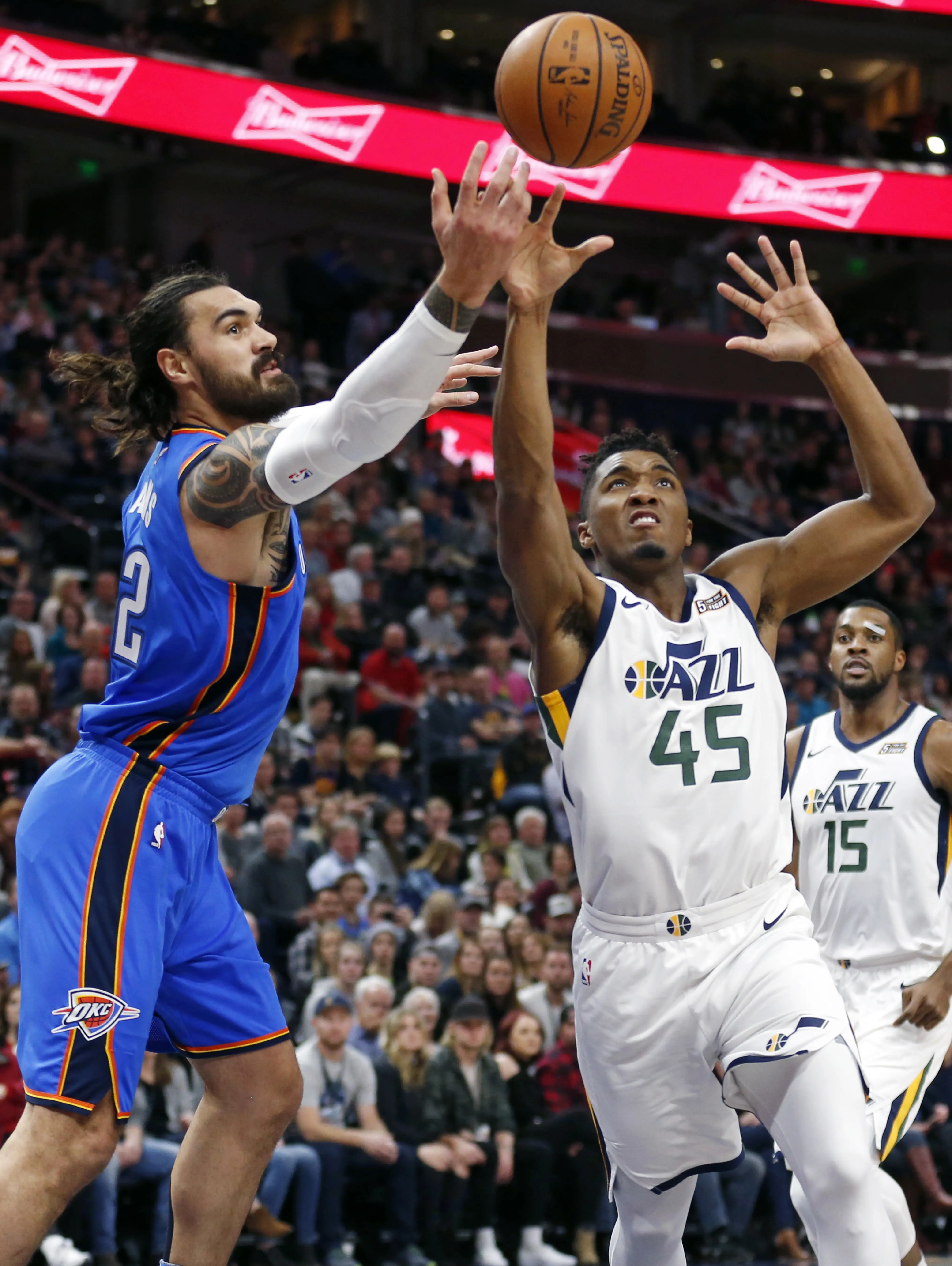 Guard Utah Jazz Donovan Mitchell (kanan) berebut bola dengan center Oklahoma City Thunder Steven Adams pada laga NBA di Vivint Smart Home Arena, Sabtu (23/12/2017) atau Minggu (24/12/2017) WIB. (AP Photo/Rick Bowmer)