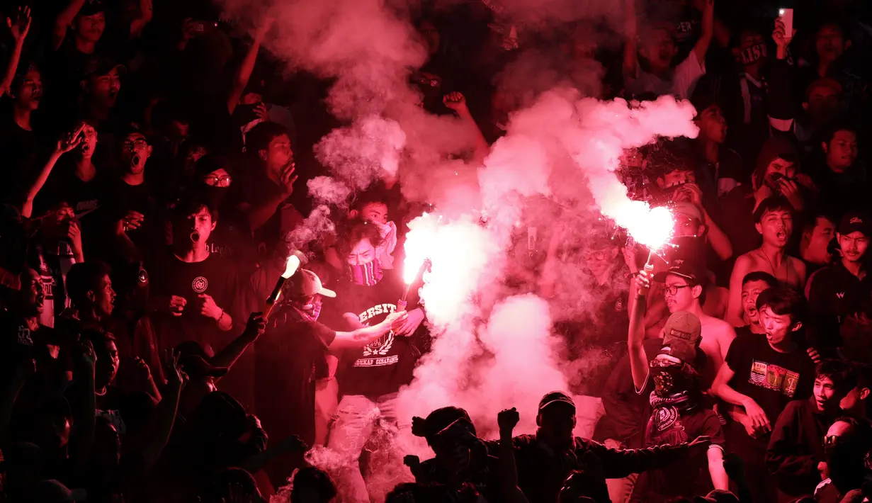 Suporter Persita Tangerang menyalakan flare saat melawan Arema FC pada laga Piala Indonesia 2019 di Stadion Sport Center Kelapa Dua, Tangerang, Minggu (3/2). Arema FC menang 3-0 atas Persita. (Bola.com/M Iqbal Ichsan)